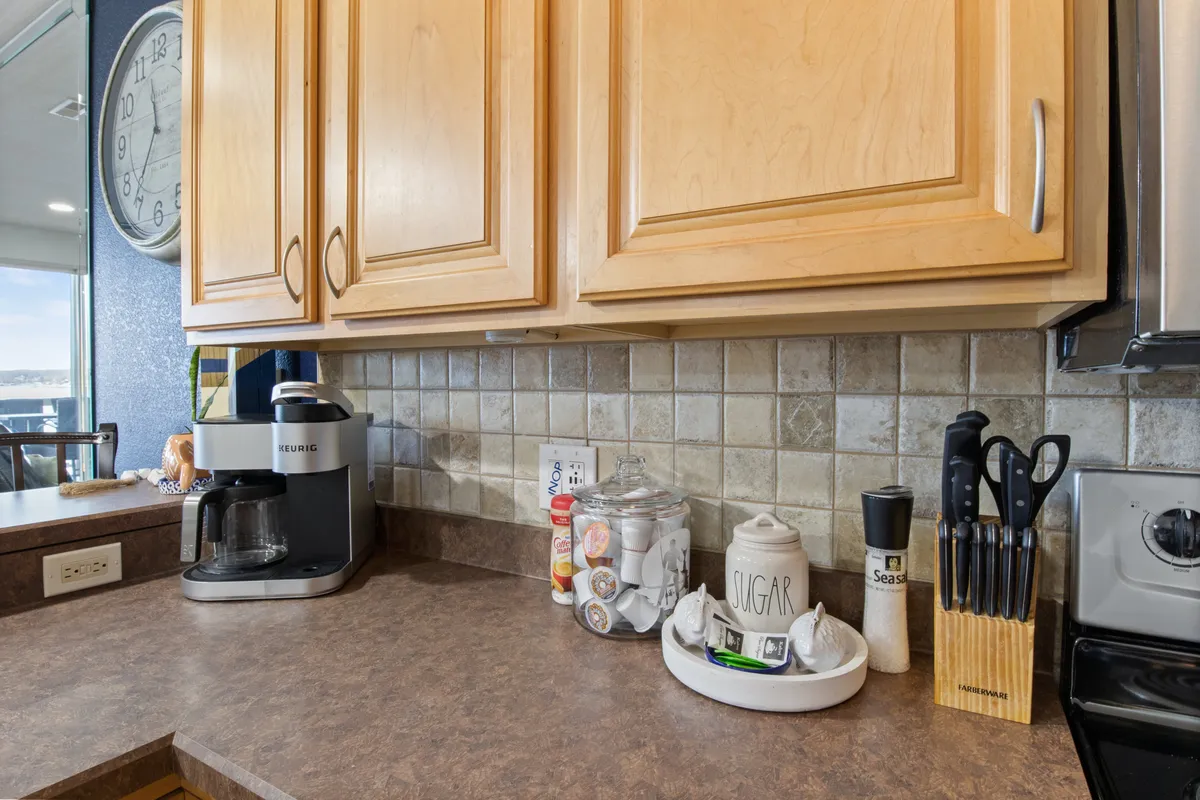 A warm kitchen scene featuring wooden cabinets, a coffee maker, and thoughtfully arranged kitchen essentials. The setup suggests attention to detail and readiness for guest use, making mornings and mealtimes easy and enjoyable.
