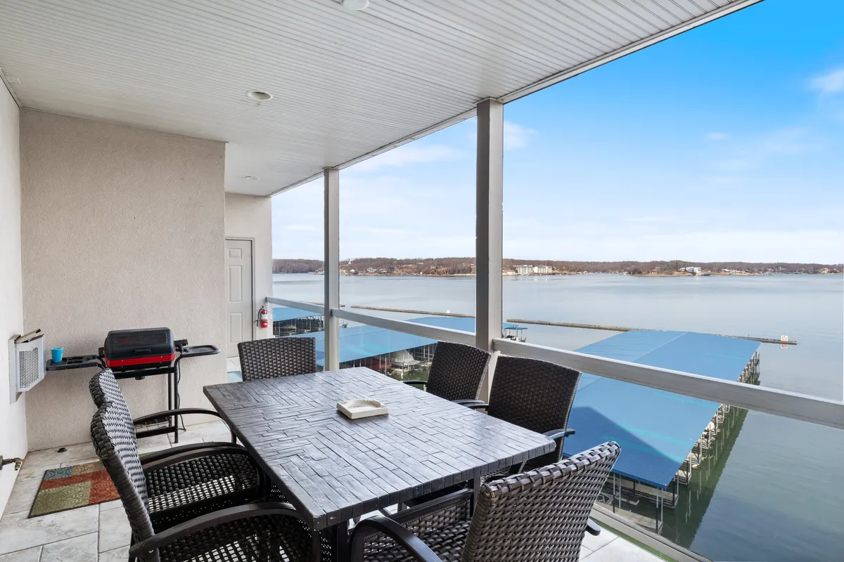 A welcoming balcony with a dining table, grill, and a stunning view of the water—perfect for alfresco meals or sunset gatherings. The scene suggests a seamless indoor-outdoor living experience, ideal for groups returning from a day’s adventure.